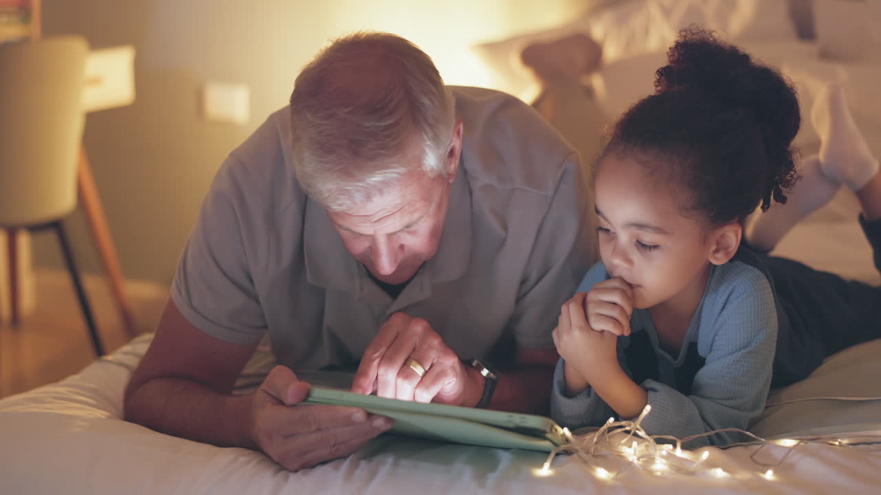 Notte, tablet e nonno con bambino