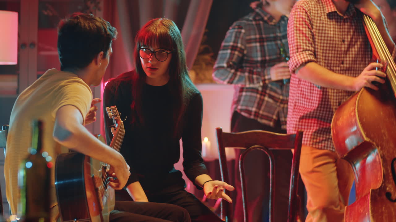 guitarrista con charla con su novia en la fiesta después del concierto