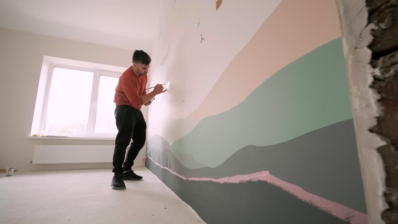 el artista está decorando las paredes con dibujos en la habitación de los niños. pintura de arte de las paredes en la casa nueva. trabajos de reparación.