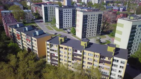 aerial view of crowded residential district apartment buildings on a sunny summer day, renovated and insulated houses, colorful walls of the facade, wide angle point of view drone shot moving left