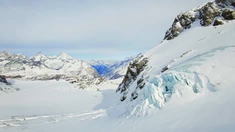 El-Dron-Avanza-A-Través-De-Una-Extensión-Montañosa-Bañada-Por-La-Nieve,-Revelando-Picos-Majestuosos-Como-Un-Impresionante-Telón-De-Fondo.