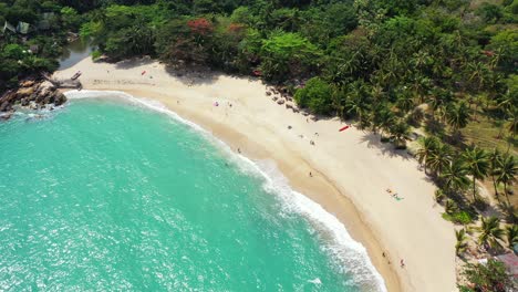 Ruhiger,-Exotischer-Strand-Mit-Weißem-Sand-Neben-Palmenwäldern-Und-Wunderschönen,-Vom-Meerwasser-Umhüllten-Klippen-Der-Türkisfarbenen-Lagune-In-Thailand