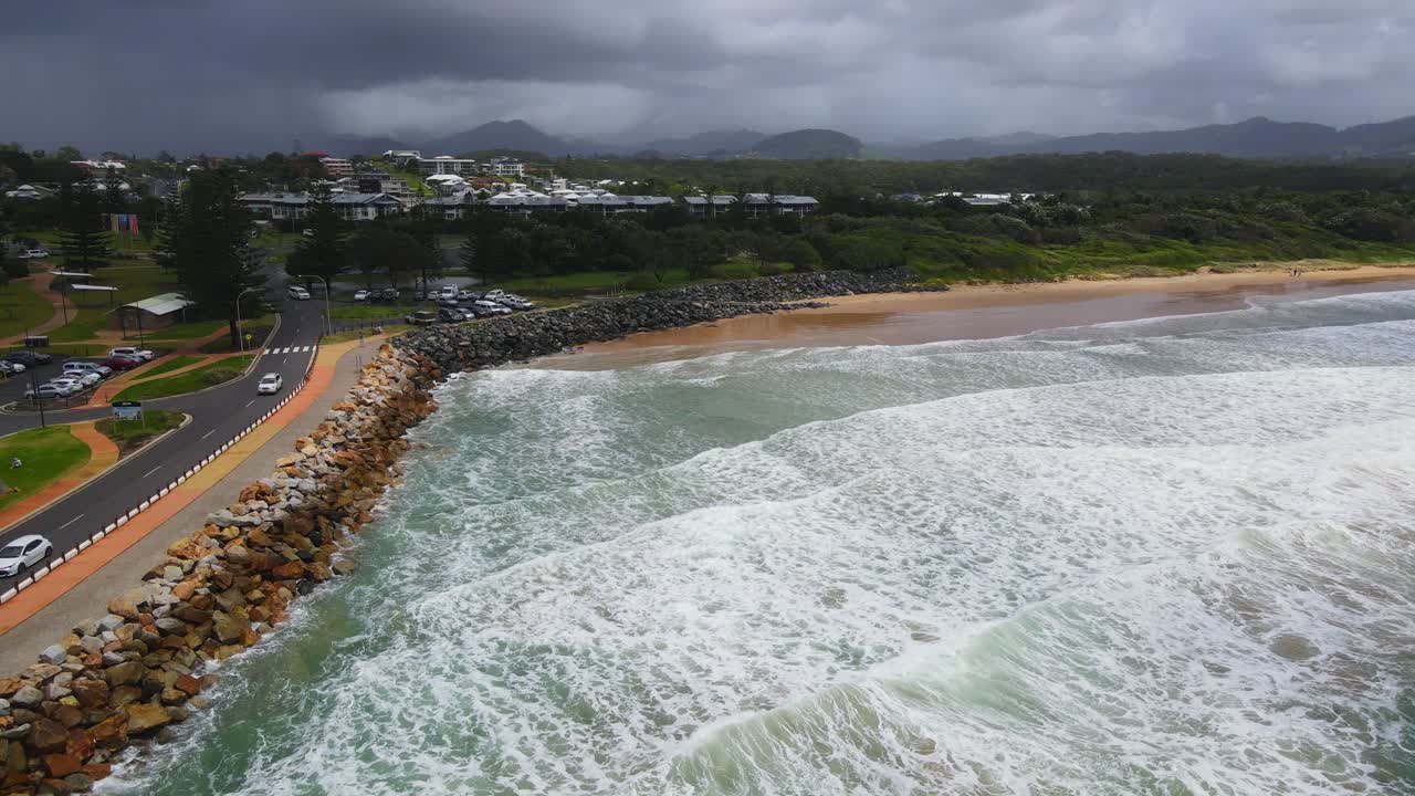 coches circulando en marine drive con olas rompiendo en seawall y northwall beach - coffs harbour, nueva gales del sur, australia