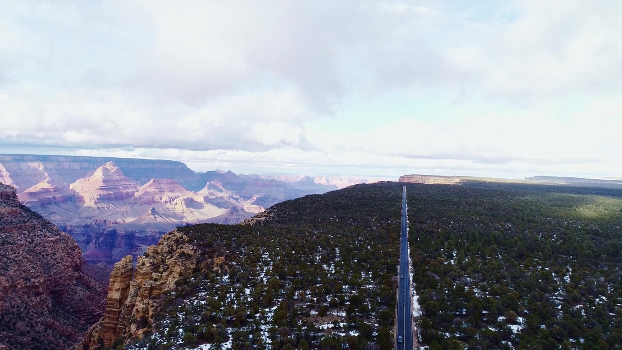 Toma aérea de dron alejándose sobre la carretera del borde del Gran Cañón, cerca de Desert View, Arizona, EE. UU.