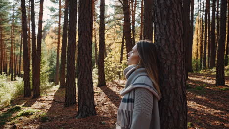 woman enjoying the sunlight in an autumn forest