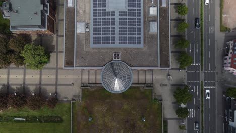 large sustainable public building with solar roof, aerial top-down