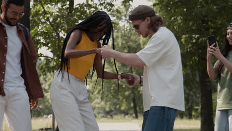 friends having fun and dancing together in a park