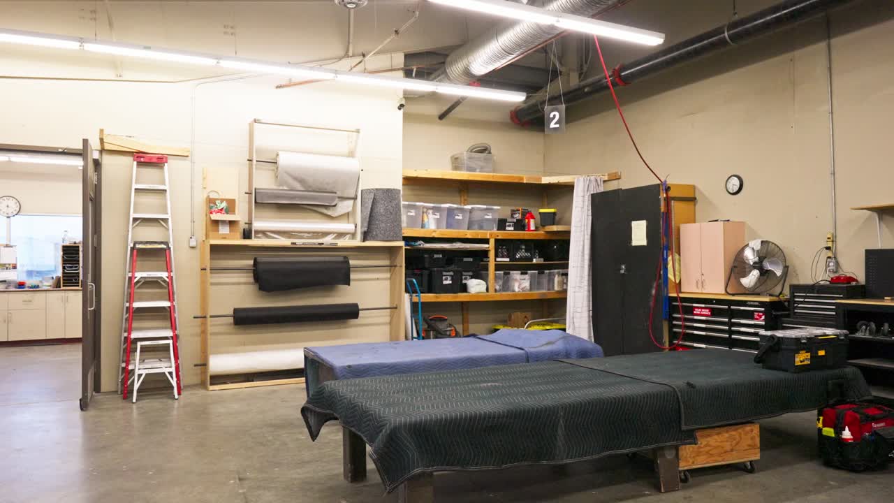 Tracking shows fabric rolls and wooden tool shelf in industrial workshop interior