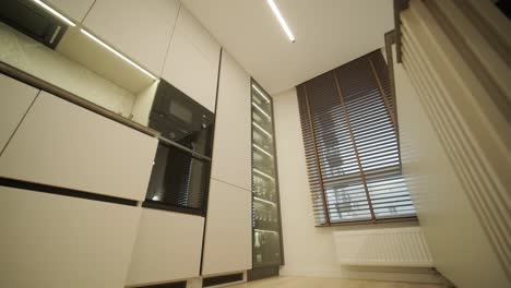 interior de cozinha minimalista moderno com grandes janelas e tons neutros