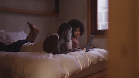 couple using computer in bedroom at home