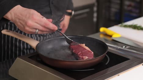 chef cooking steak in a pan