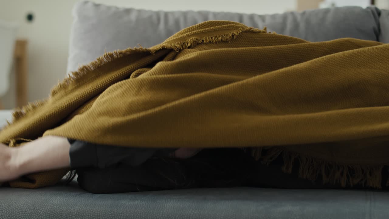 mujer triste caucásica cubriendo la manta en casa.