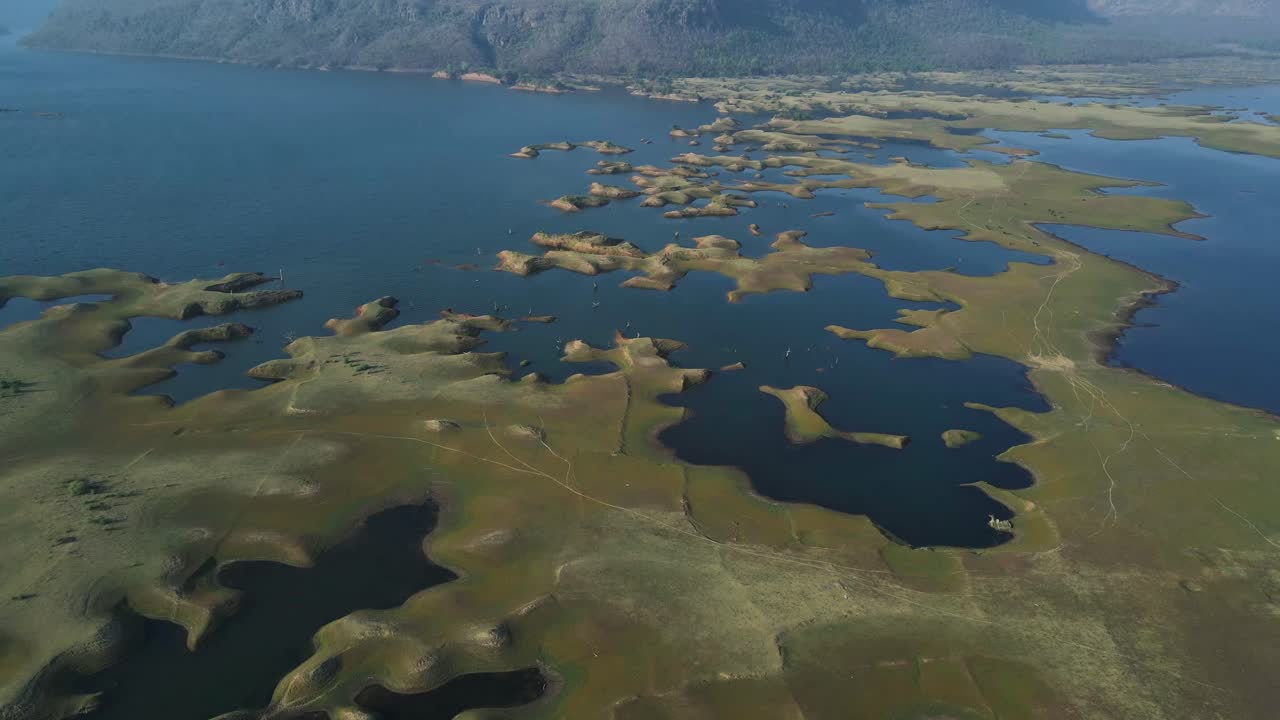 Drone shot of Karamchat Dam, with water spilling over and cascading down the dam’s spillways.