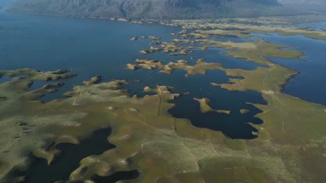 drone shot of karamchat dam, with water spilling over and cascading down the dam’s spillways.