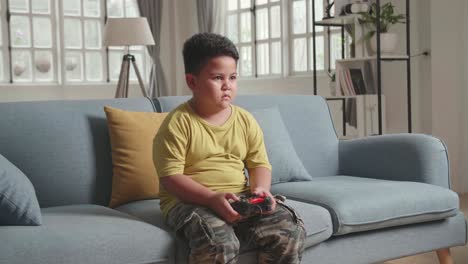 little boy's hand using joystick while playing game at home