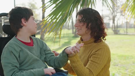 woman interacting with a boy in a wheelchair