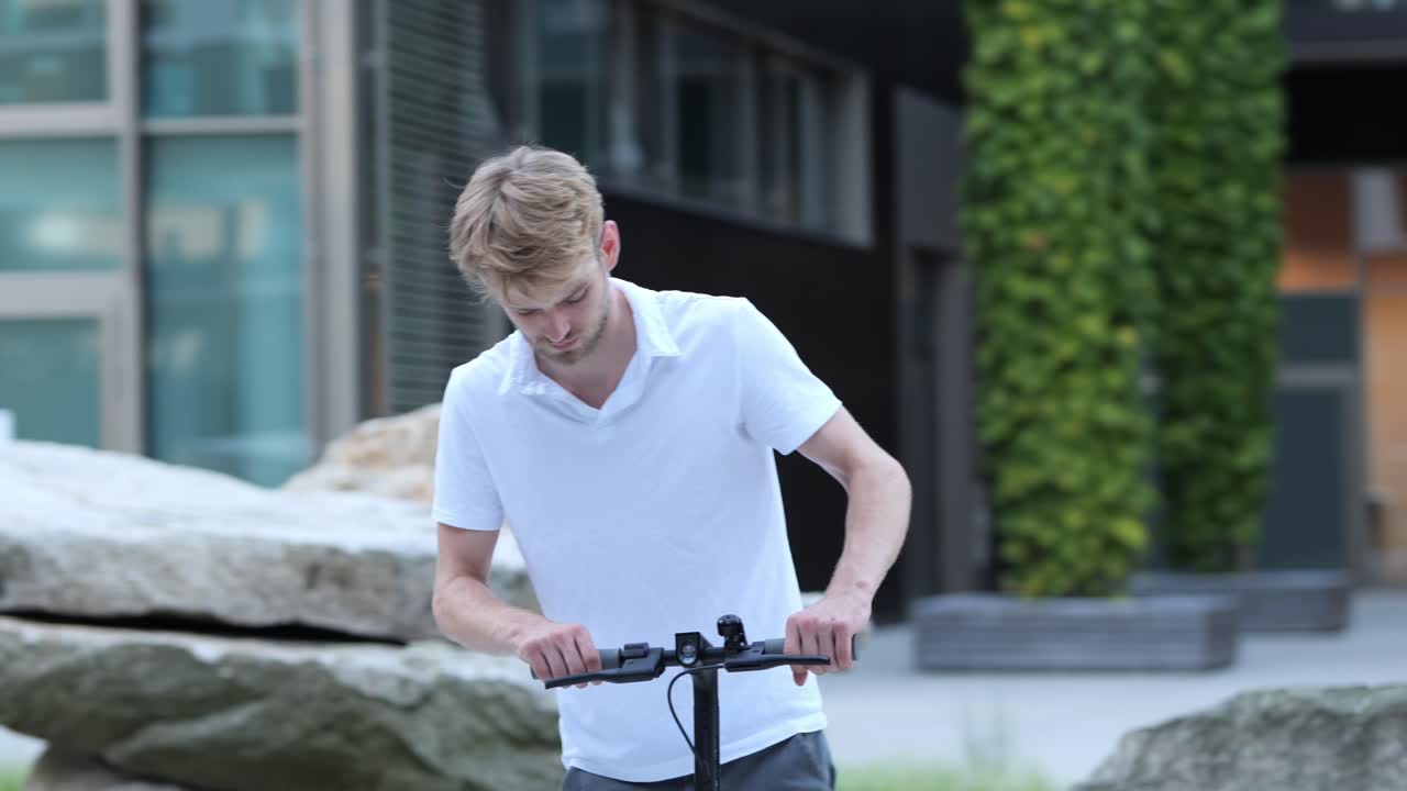 젊은 사업가가 그의 전자 스쿠터로 걸어가서, 도에 니다.