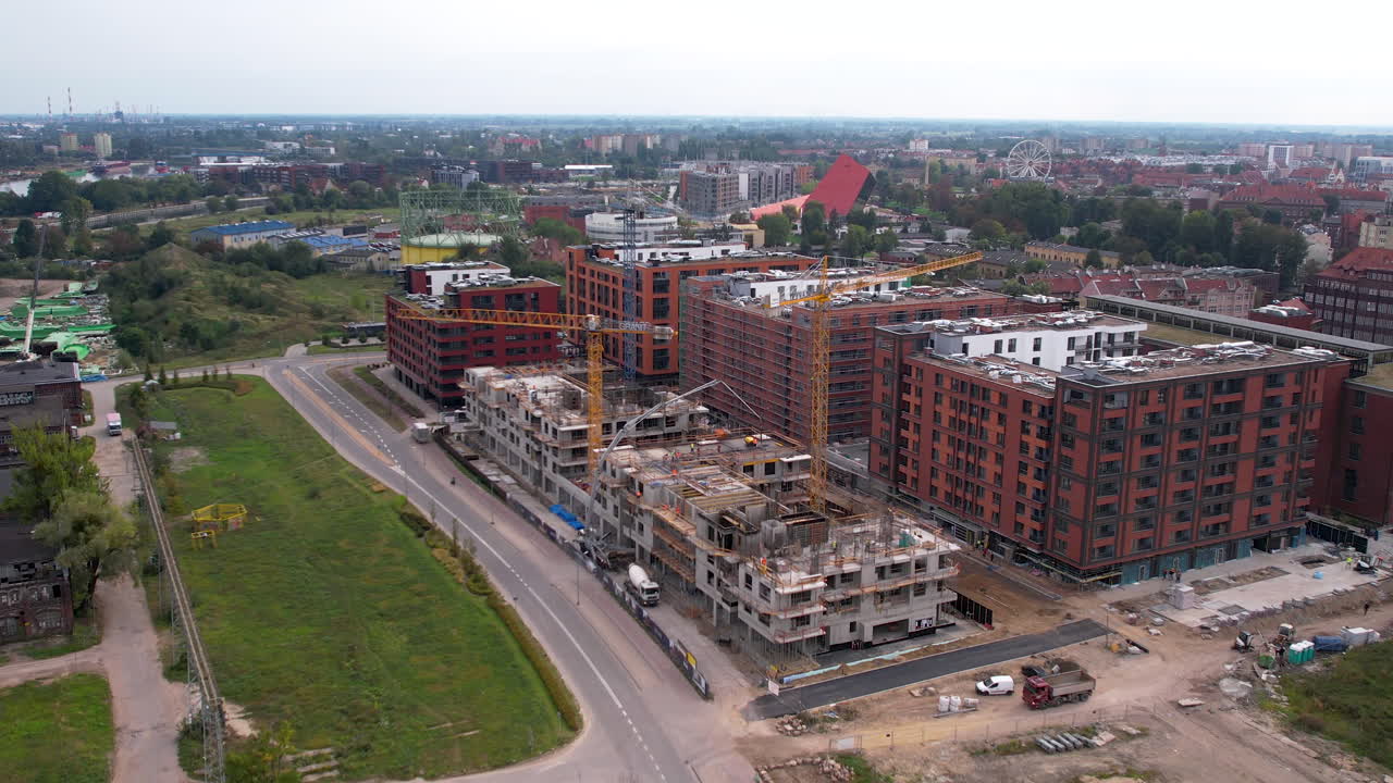 aérea - construcción de un moderno complejo residencial y de oficinas en el centro de gdańsk - sitio de construcción con grúas y equipos de construcción pesados - obras de ingeniería avanzadas - rascacielos