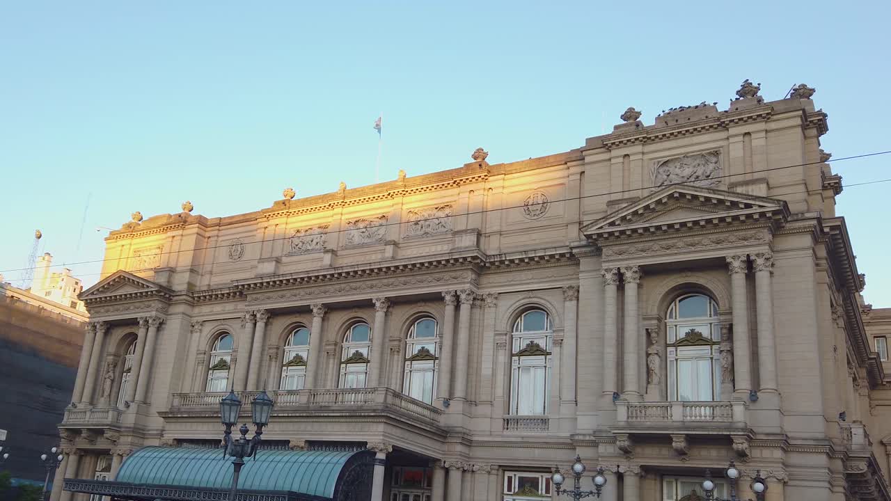 Teatro Colón, a historic opera house in Buenos Aires, Argentina establishing pan of iconic cultural landmark with golden light across roof