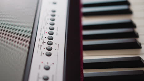 Kid-presses-key-and-plays-electrical-piano-at-music-lesson