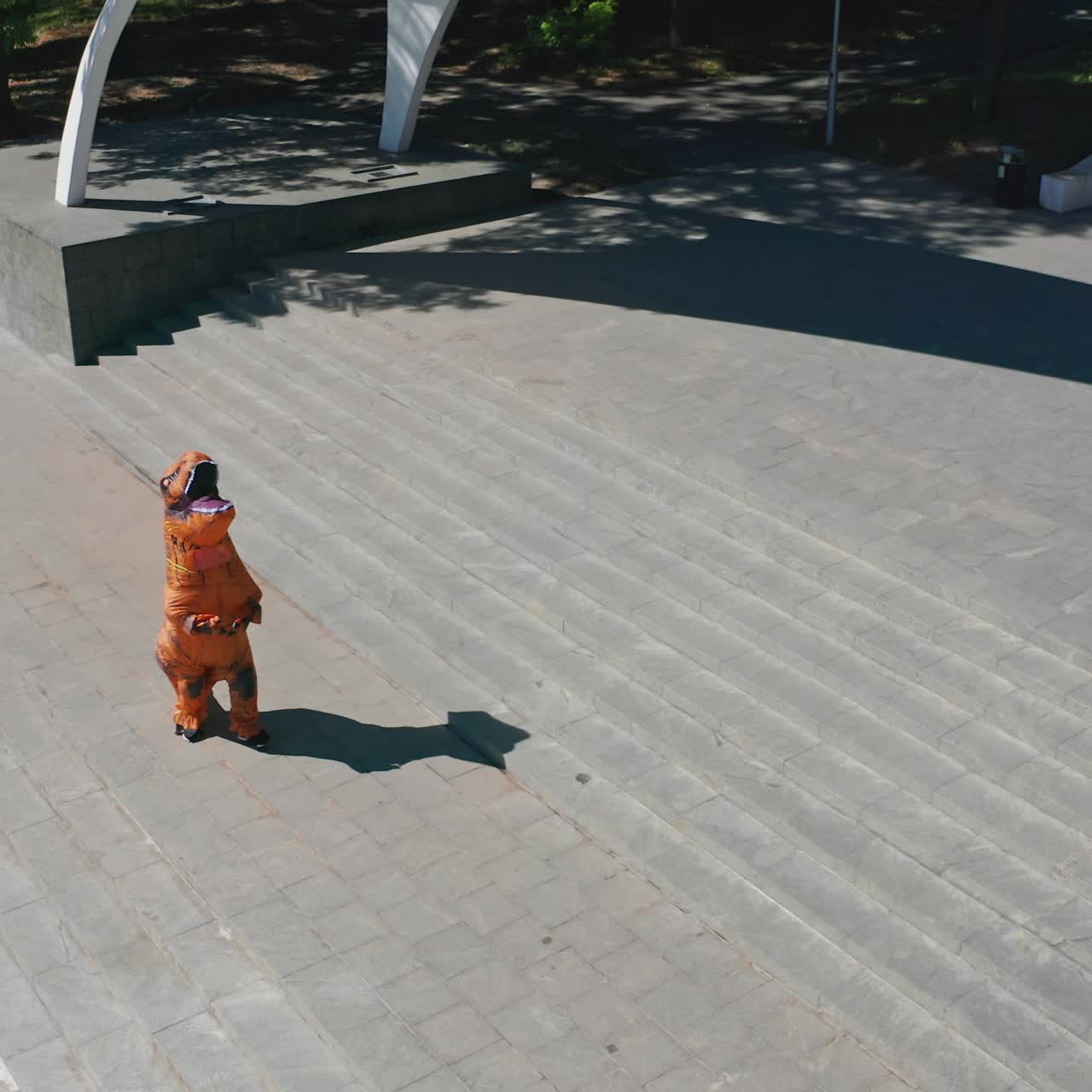 Happy crazy dragon costume in the city. Funny dragon costume walking in the park