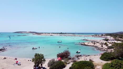 aerial of elafonisi bay and beach, tourists, boats and wind surfers, drone