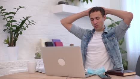retrato de un joven empresario que se quita la máscara en el lugar de trabajo. trabajo seguro en tiempos de pandemia
