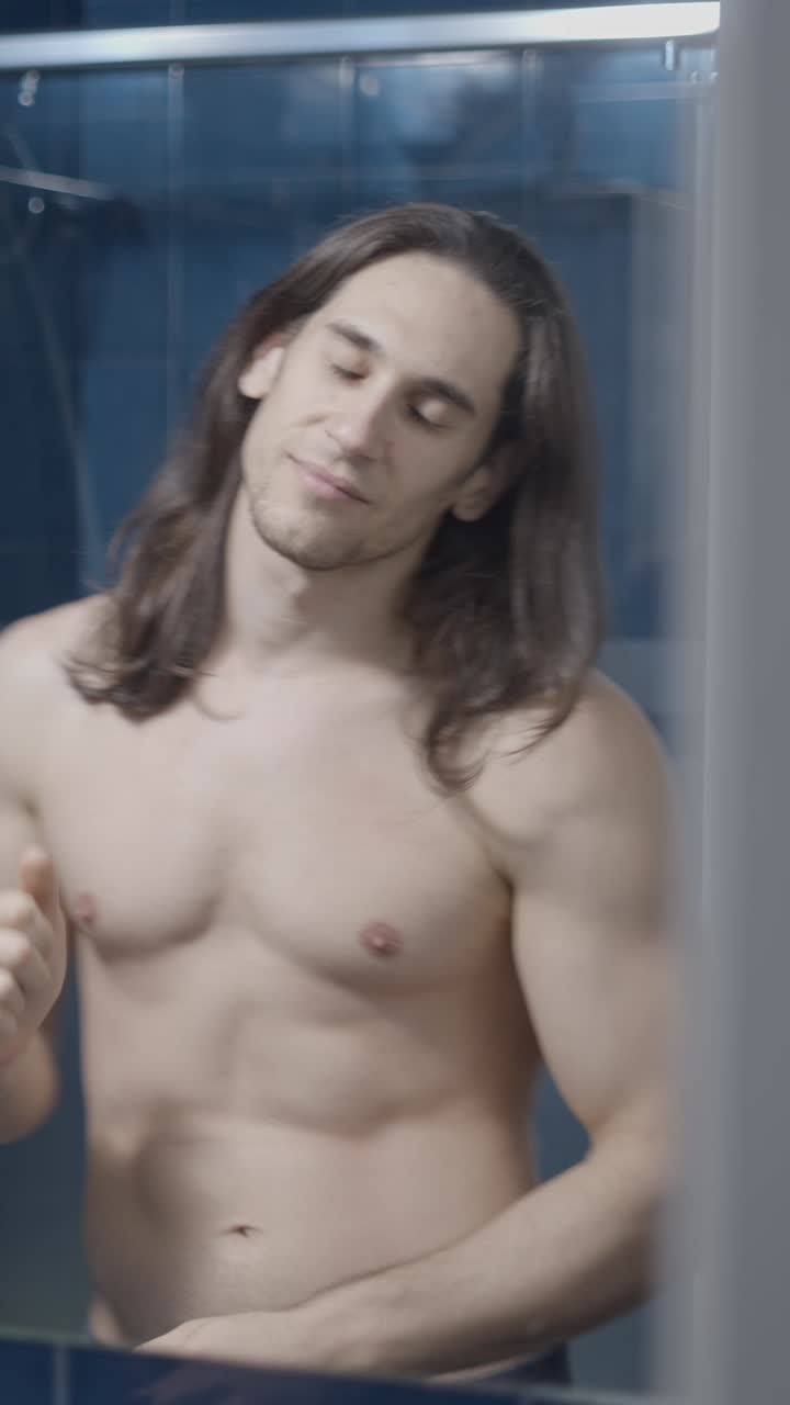 Man with Long Hair Shirtless in Bathroom Mirror