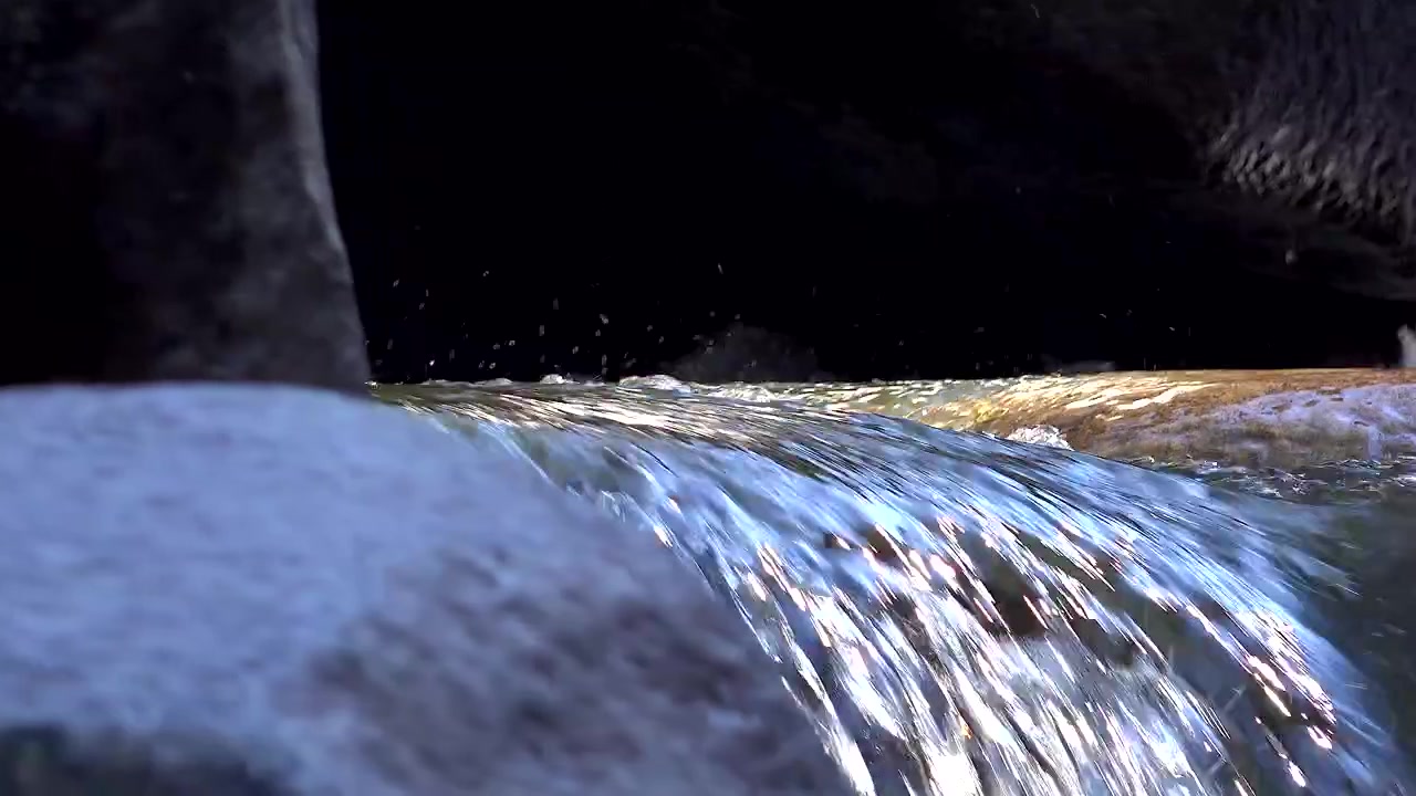Primo piano di acqua limpida che scorre sulle rocce in un ruscello