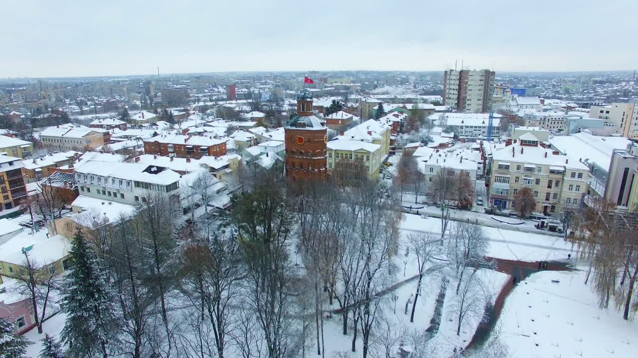 Downtown of the Ukrainian city Vinnytsia with historic buildings. Flying above the old tower and other architecture covered with snow.