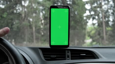 maqueta de pantalla verde de un teléfono inteligente dentro de un coche con tráfico en el fondo.