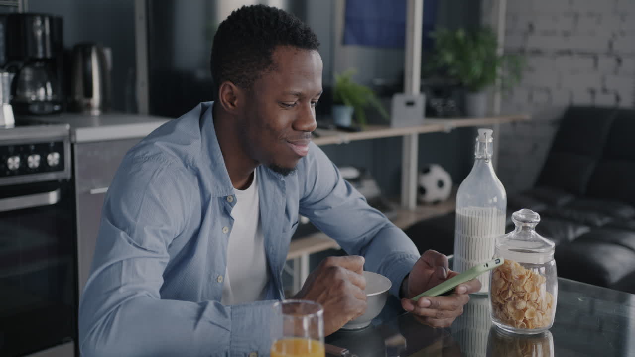 Man having breakfast and looking at his phone