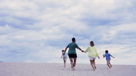 family running on the beach