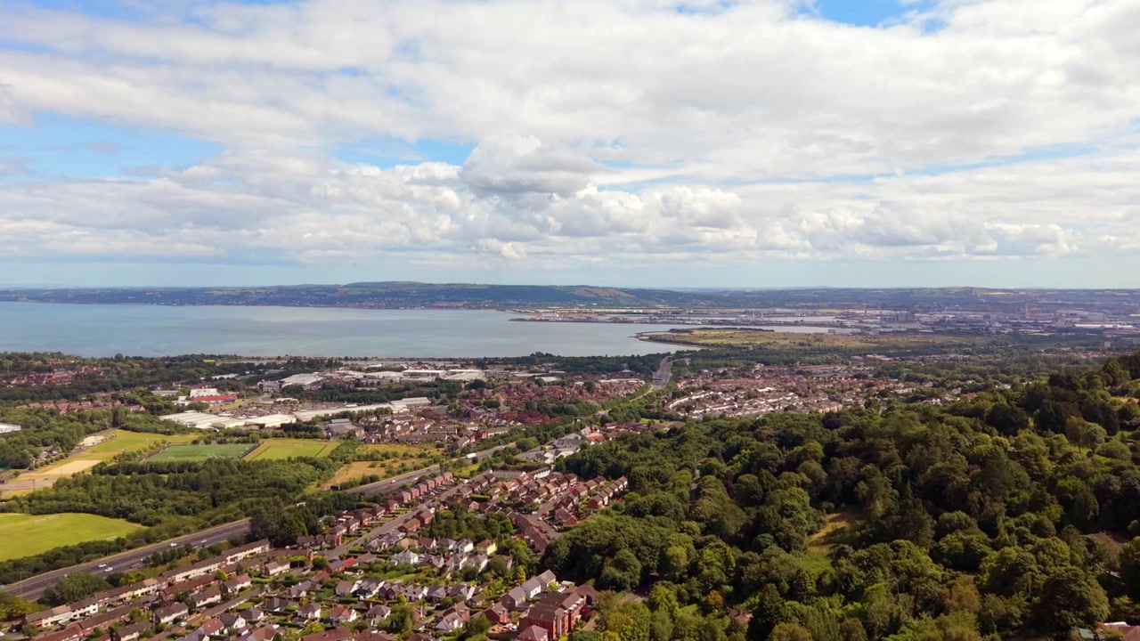 Szerokie wideo lotnicze 4K 60FPS z Belfastu, z Cavehill, Irlandia Północna w Wielkiej Brytanii, w jasny, słoneczny dzień. Wyprodukowano z kolorem Rec709