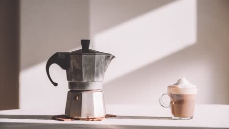 Glas-Latte-Macchiato-Mit-Moka-Topf,-Serviert-Auf-Dem-Tisch-Bei-Tageslicht