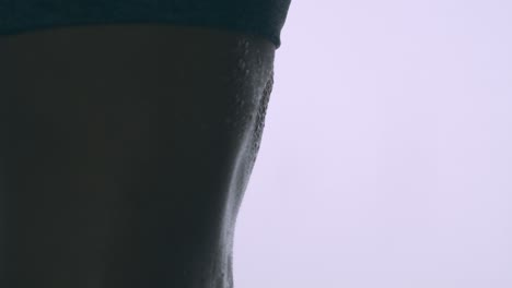 close up isolated view of sweat droplets on the muscular stomach of a woman exercising