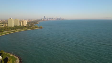 Toma-Aérea-Revela-Un-Punto-Promontorio-Con-El-Horizonte-De-Chicago-En-El-Fondo