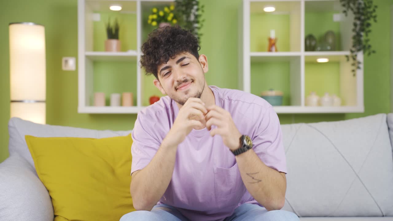 젊은이가 웃고 심장을 만들고 있습니다.