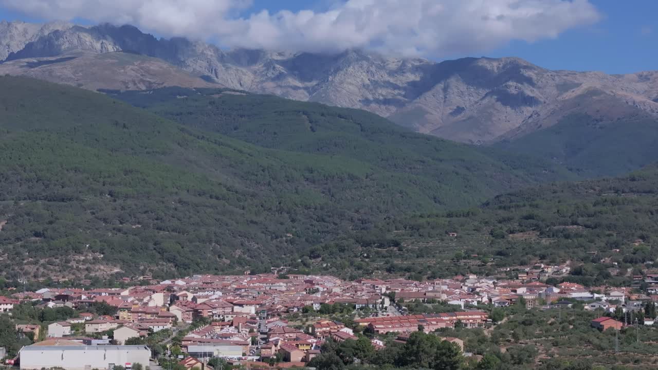 70mm drone filming of the town of Candeleda in Avila with its majestic background of mountains where the clouds appear hooked, we appreciate all this with a camera movement from top to bottom