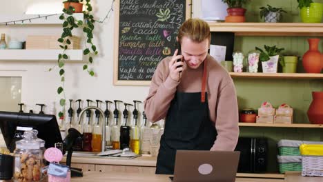 in the modern cozy coffee shop barista guy using the laptop to type a new online order from the customer concept of coffee shop owner and small business entrepreneur