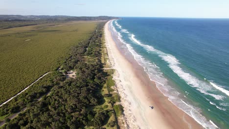 seven mile beach with vegetated shoreline of lennox head in summer. nsw, australia. aerial shot
