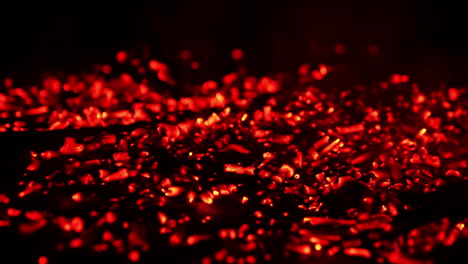 pile of glowing charcoal after the campfire burnt out. red pieces of burned wood still hot. close up.