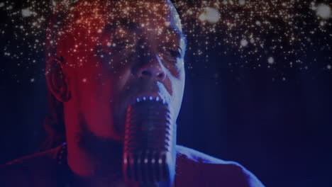 male singer using microphone on stage, blending red blue lights with shimmering graphics for music