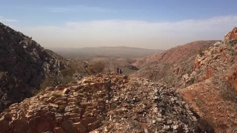 kings canyon australia, couple standing with arms outstretched on mountain