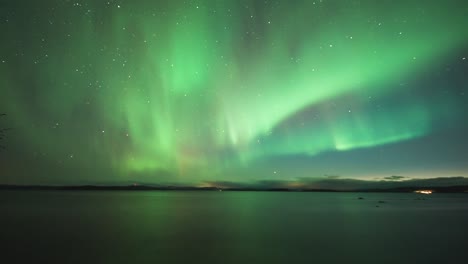 A-mesmerizing-dance-of-the-green-and-purple-northern-lights-in-the-night-sky-above-the-dark-waters-of-the-Norwegian-fjord