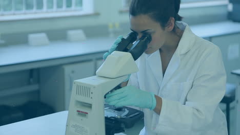 video de una científica caucásica usando un microscopio en el laboratorio
