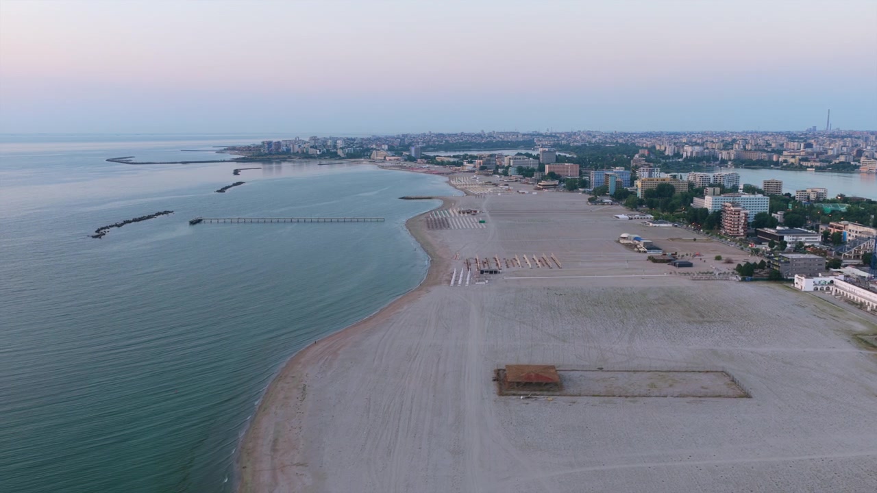 Pantai Mamaia membentang di sepanjang Laut Hitam dengan bangunan kota dan dermaga. Rumania.
