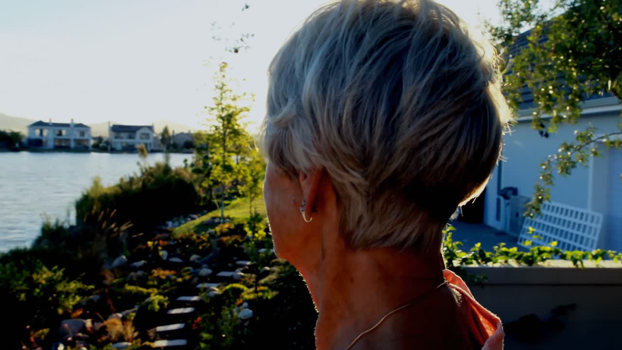 Anziana signora in piedi in giardino 4k
