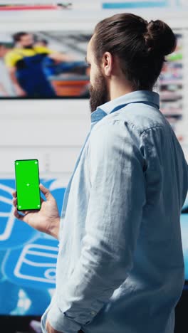 vertical video young adult holds phone with chroma key screen and connecting on socials