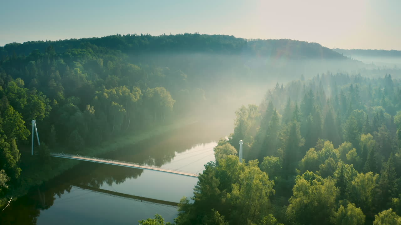 霧の川にかかる驚くべき現代的な橋、橋の上を歩く人、空撮